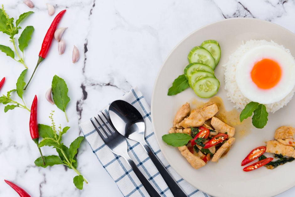 Delicious Thai chicken stir fry with steamed rice and a sunny side up egg.