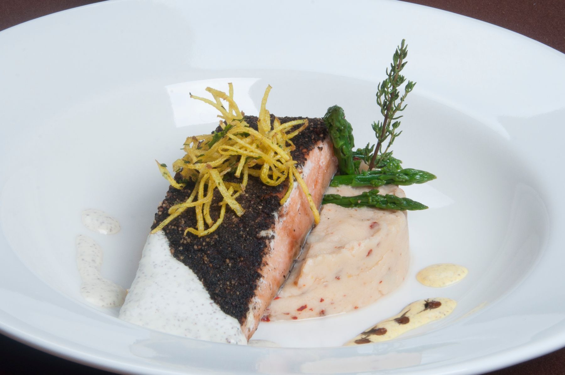 Blackened salmon with asparagus and mashed potatoes on a white plate.