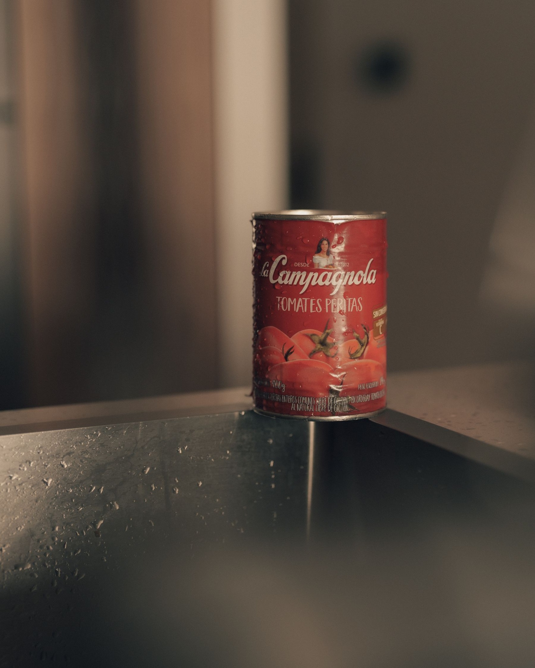 Close view of a tomato can at a kitchen sink.