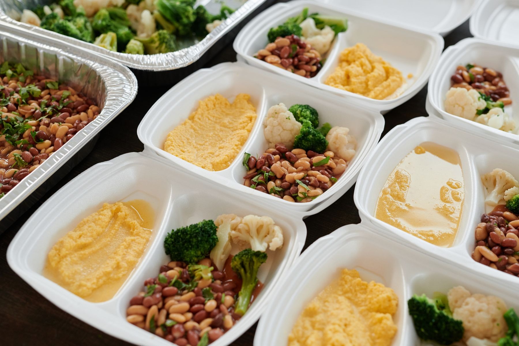 Food containers with broccoli, beans and mashed potatoes.